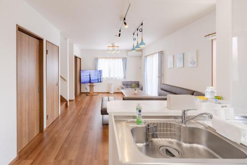 a kitchen with a sink and a living room at Fujiyama Stay in Fujinomiya