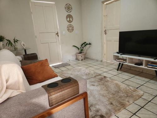 a living room with a couch and a flat screen tv at Casa simples e funcional in Aimorés