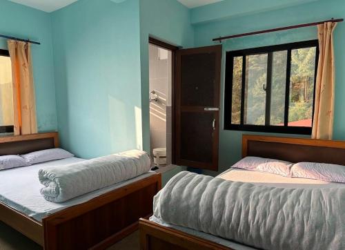 a bedroom with two beds and a window at Hotel Shangbola in Pāti Bhanjyāng
