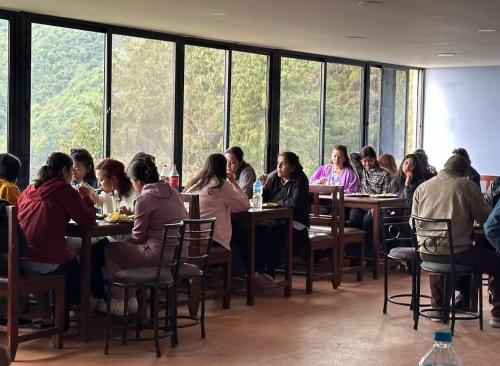 a group of people sitting at tables in a restaurant at Hotel Shangbola in Pāti Bhanjyāng