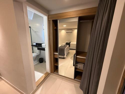 a room with a glass door to a room with a bedroom at Hotel Pousada Casacolina in Búzios