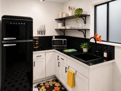 a kitchen with white cabinets and a black refrigerator at The Creative Escape With Community Canvas Loft in Coeur d'Alene