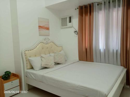 a bedroom with a white bed with a headboard at Grand Riviera neas Slec in Manila