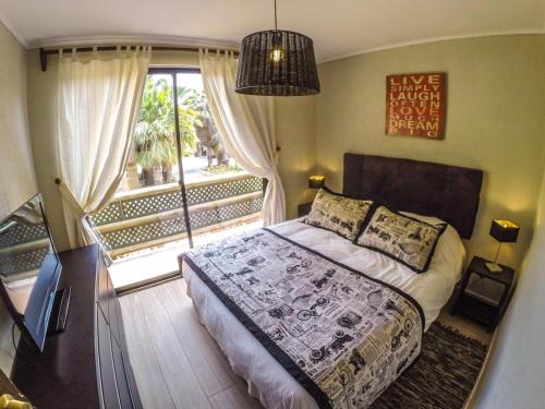 a bedroom with a bed and a large window at Apart Hotel Gran Pacifico in La Serena