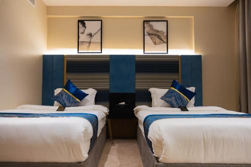 two beds in a room with blue and white at فندق لامار بارك - العليا in Tabuk