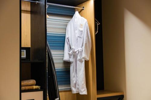 a white robe is hanging in a closet at فندق لامار بارك - العليا in Tabuk