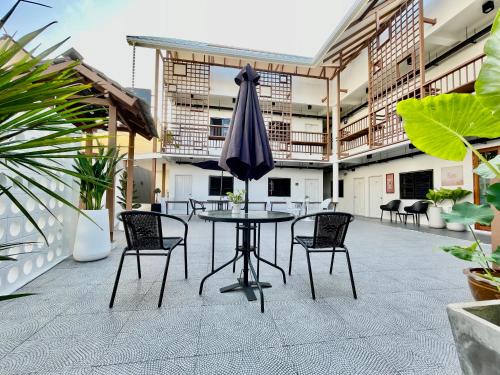 a patio with a table and chairs and an umbrella at Secret Corner Boutique Stay in Chiang Rai