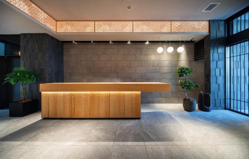 a reception desk in a lobby with plants at Anran Hotels&Resorts in Osaka