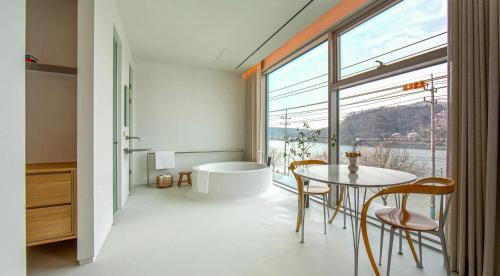 a bathroom with a tub and a table and chairs at Ripple Boutique Hotel in Yangpyeong