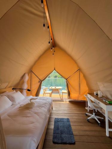 a bedroom in a tent with a bed and a desk at Reef Resort - Samal Island View Unit C4 in Kaputian