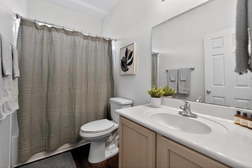 a bathroom with a white toilet and a sink at Sonesta Tucson in Tortolita