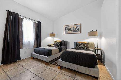 a room with two beds and a couch and a window at Sonesta Tucson in Tortolita