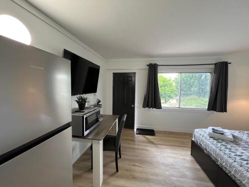 a room with a desk and a bed and a window at Stampeder Inn in Williams Lake