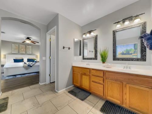 a bathroom with two sinks and a bedroom with a bed at Karsten Maricopa in Maricopa