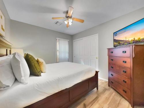 a bedroom with a bed with a ceiling fan and a dresser at Karsten Maricopa in Maricopa