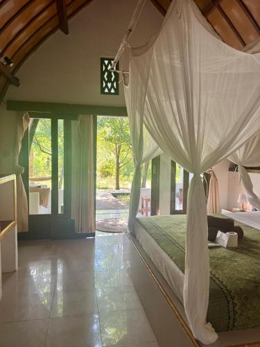 a bedroom with a bed with a canopy at Rising Sun Bungalows in Gili Meno