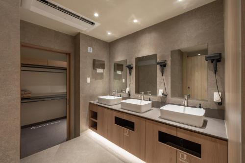 a bathroom with two sinks and two mirrors at Kanso Stay Jongno in Seoul