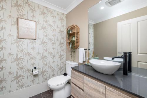 a bathroom with a white toilet and a sink at Chelsea Poolside and Tennis in Nelson Bay