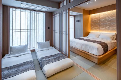 two beds in a room with large windows at Anran Hotels&Resorts in Osaka