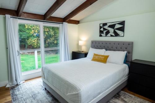 a bedroom with a bed and a large window at Dip and Dink Catskills Poolside Oasis in White Lake