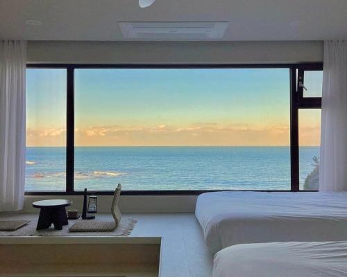 a bedroom with a large view of the ocean at Ulsan Guyu Stay in Ulsan