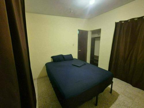 a bedroom with a blue bed in a room at Hospedaje Dinos in Veracruz