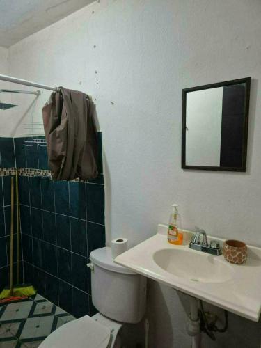 a bathroom with a toilet and a sink and a mirror at Hospedaje Dinos in Veracruz