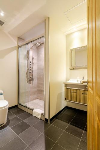 a bathroom with a shower and a sink at Ski-in, Ski-out Iwatake Apartments in Hakuba