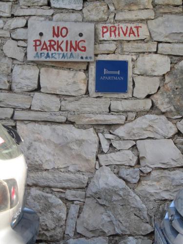 a stone wall with no parking signs on it at Apartment Petrović in Korčula