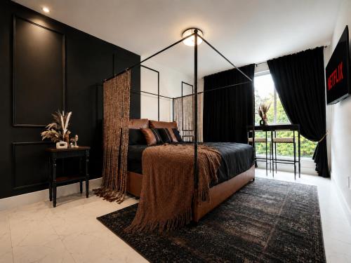 a bedroom with a bed with a canopy at Oasis on Monroe Aparthotel in Hollywood