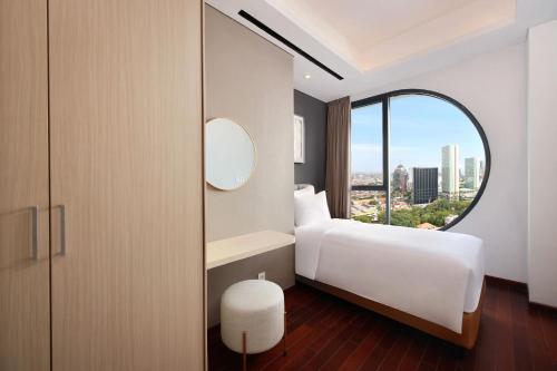 a bedroom with a bed and a large window at Vasa Suite Surabaya in Surabaya