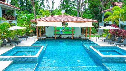 a swimming pool with a table and an umbrella at Bungalows Punta Uva in Puerto Viejo