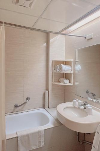 a bathroom with a sink and a tub and a toilet at Dongpo Ti Lun Hotel in Xinyi