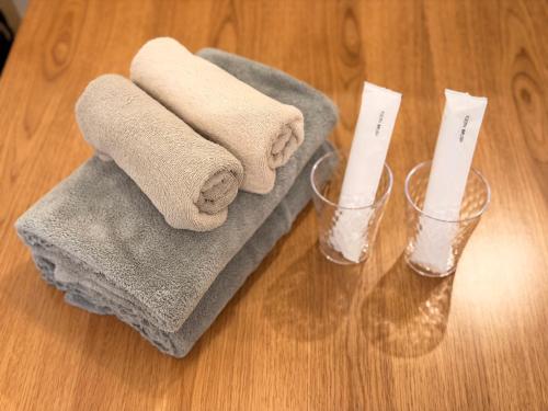 two towels and two candles sitting on a table at ura BETTEi 別邸 in Okayama