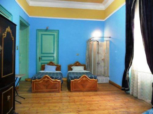 a blue room with two beds in it at Berlin Hotel in Cairo