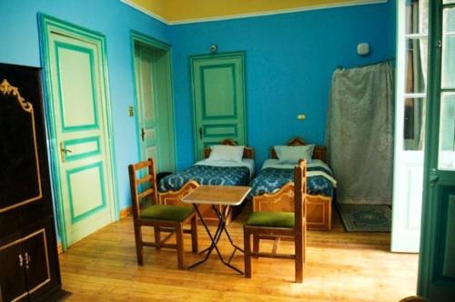 a bedroom with a bed and a table and chairs at Berlin Hotel in Cairo