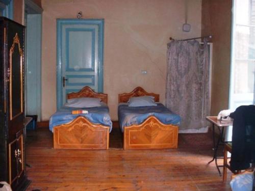 a room with two beds in a room with a window at Berlin Hotel in Cairo