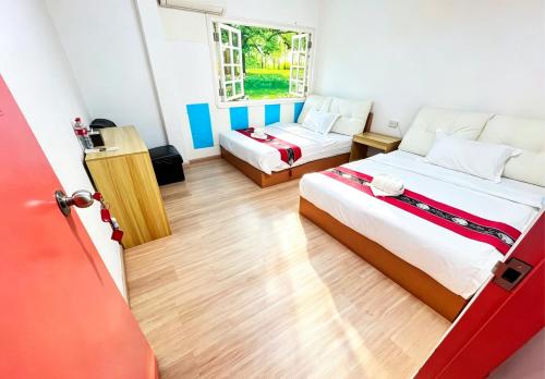 a small room with two beds and a window at BG prosper Hostel in Ban Don Muang (1)