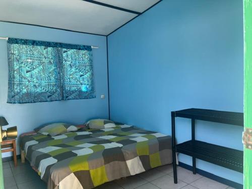 a bedroom with a bed and a blue wall at Camping Hiva Plage in Parea