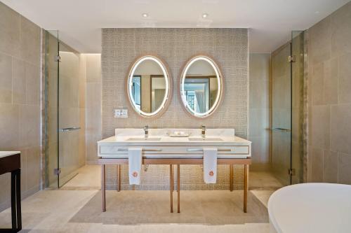 a bathroom with a sink and two mirrors at Angsana Oceanview Residences Building 2 in Laguna by Banyan Living in Bang Tao Beach