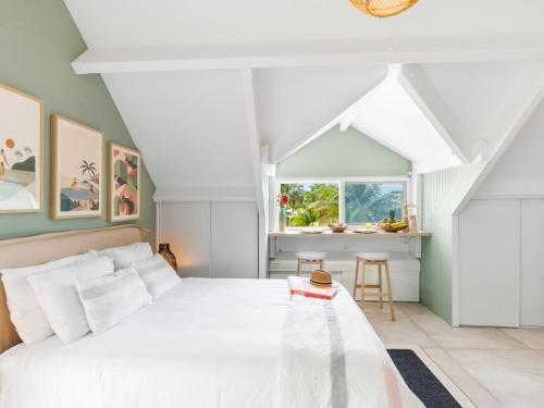 a bedroom with a white bed and a window at Shell Beach - Magnifique Loft sur la plage in Baie Nettle
