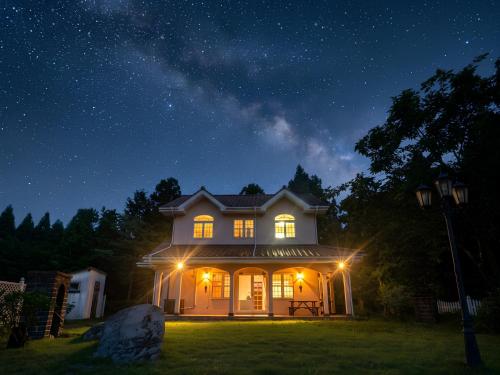 a house lit up at night with lights on at Star Peak Villa 黒川 in Minamioguni