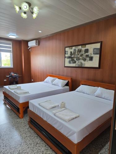 two beds in a room with wooden walls at MSD Resort Hotel in Bengcag