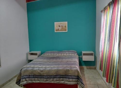 a bedroom with a blue wall and a bed at CATALINA in Neuquén