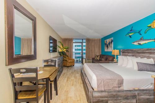 a hotel room with a bed and a desk and a table at Landmark 618 in Myrtle Beach