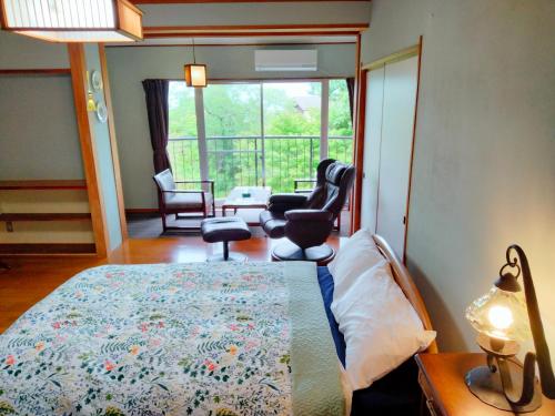 a bedroom with a bed and a living room at ウテナ2 in Ito