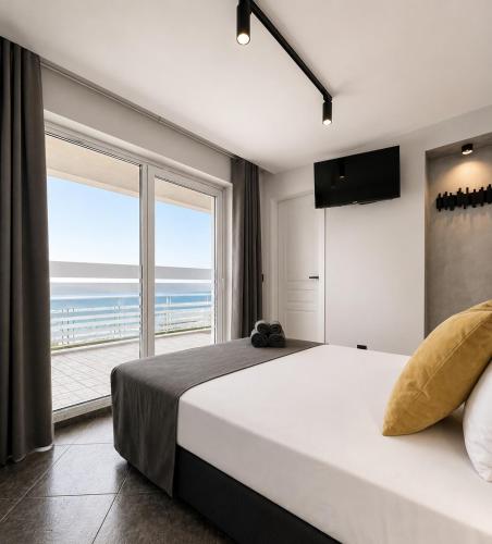 a bedroom with a large bed with a view of the ocean at AGATA BEACH Boutique -Adult Only in Ahtopol