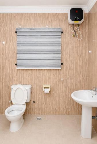 a bathroom with a toilet and a sink and a window at Executive Private Bed and Bath in Otta