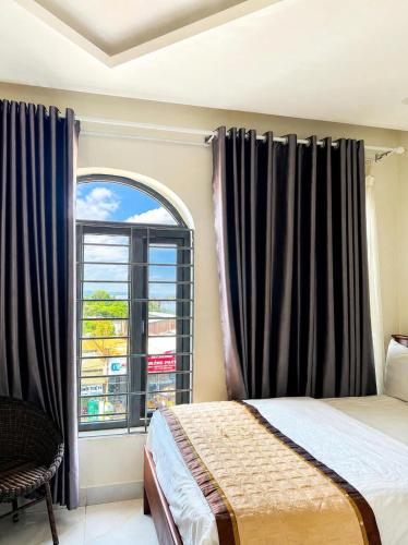 a bedroom with a bed and a large window at Hoàng Khiêm Hotel in Mỹ Thạch