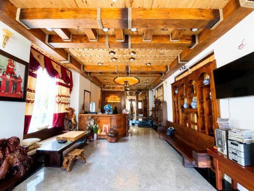 a large living room with wooden ceilings and a television at Hoàng Khiêm Hotel in Mỹ Thạch